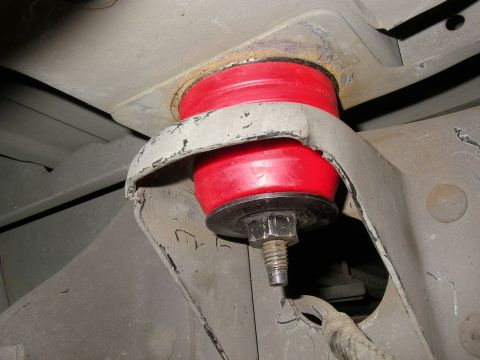 1990 Ford Bronco - Close-up view of a red polyurethane suspension bushing, likely an aftermarket upgrade, attached to the vehicle's frame.