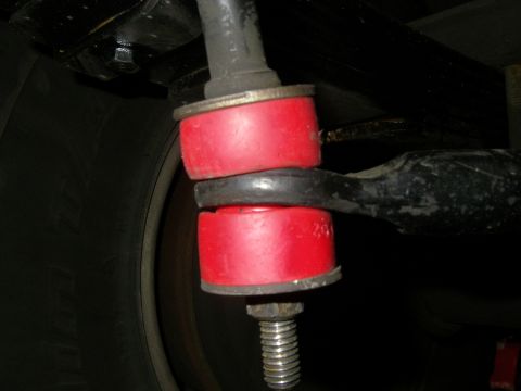 1990 Ford Bronco - Vehicle suspension linkage with red bushings and a bolt.