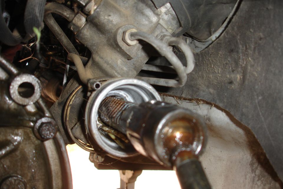 Close-up of a worn steering rack and pinion assembly with grease