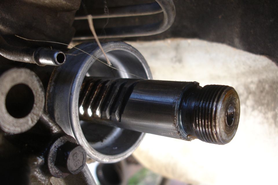 Close-up of a rack and pinion steering component with visible splines and threaded end