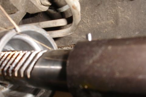 1992 Ford Taurus - Detail of a rack and pinion steering mechanism, showing the toothed rod and housing.