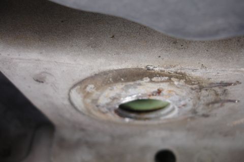 1992 Ford Taurus - A close-up view of a metal component, possibly from a vehicle's undercarriage, showing wear and some discoloration.