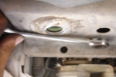 1992 Ford Taurus - Close-up of a wrench working on a vehicle's subframe during a repair.