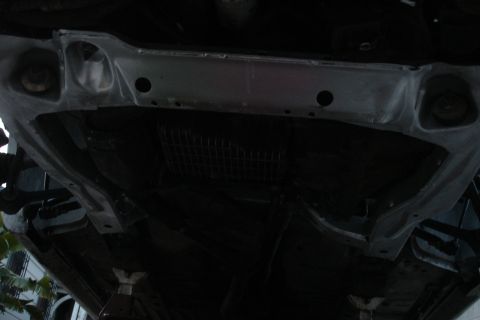 1992 Ford Taurus - Close-up view of a vehicle's underbody subframe, possibly undergoing repair or replacement.