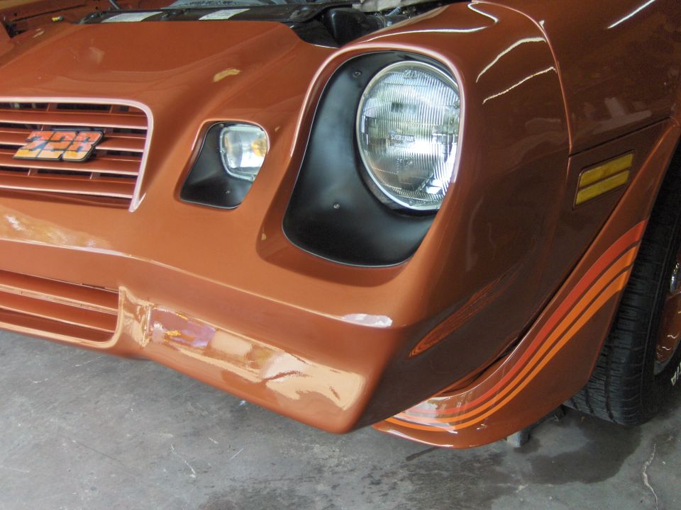 Front view of an orange 1980 Chevrolet Camaro Z28 with a Z28 badge on the grille