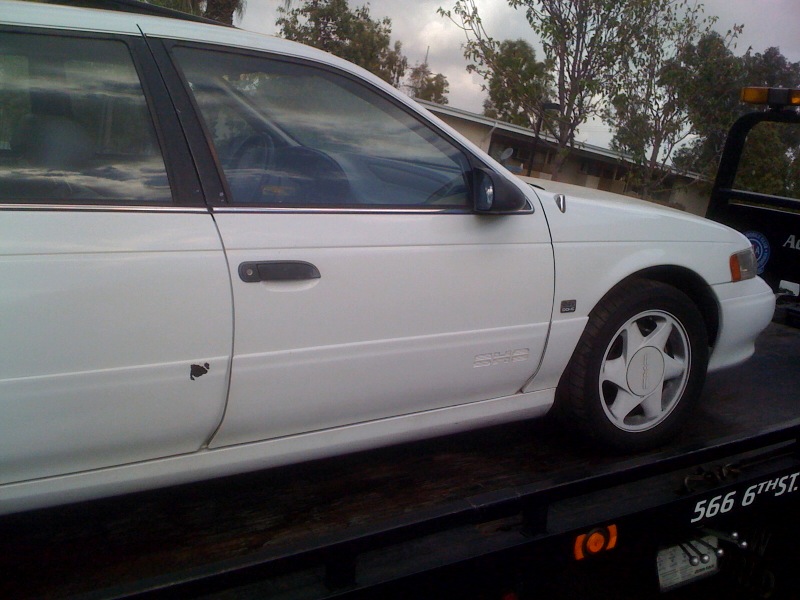 1992 Ford Taurus station wagon side view, on a tow truck bed