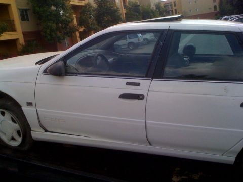 1992 Ford Taurus - Side profile of a white 1992 Ford Taurus station wagon with a sunroof.