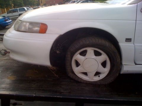 1992 Ford Taurus - This 1992 Ford Taurus has a flat tire and appears to be on a tow truck.