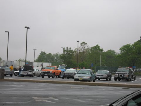 1991 Ford Crown Victoria - A variety of vehicles are parked in an outdoor lot on a cloudy day.