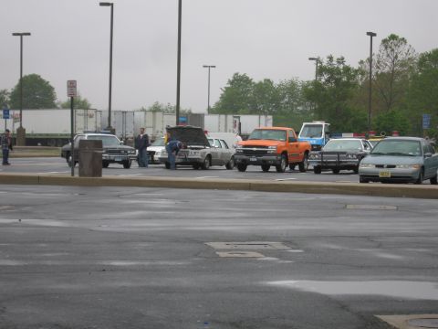 1991 Ford Crown Victoria - Multiple vehicles are parked in a lot, with one 1991 Ford Crown Victoria having its hood open.