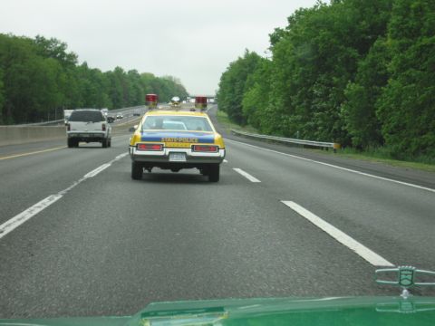 1991 Ford Crown Victoria - A vintage state police car with 'STATE POLICE' text on its trunk is seen on the highway.