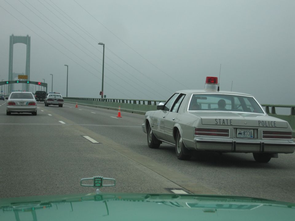 Silver State Police sedan driving on a foggy bridge approach