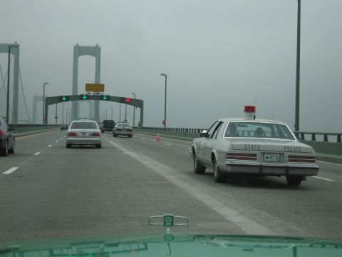 1991 Ford Crown Victoria - Driving on a bridge behind a State Police car, with other vehicles in traffic.