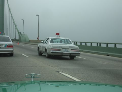 1991 Ford Crown Victoria - A state police car is seen from behind on a bridge, with a second vehicle in the adjacent lane.
