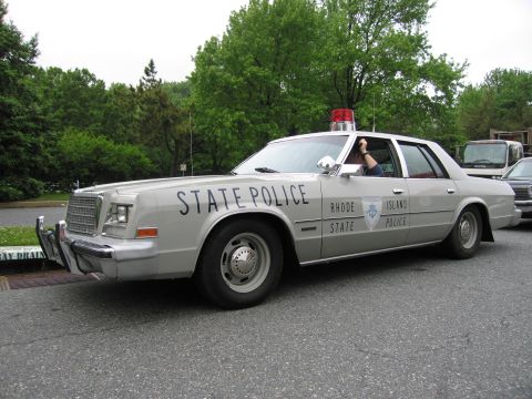 1991 Ford Crown Victoria - A Rhode Island State Police car with "STATE POLICE" and "RHODE ISLAND POLICE" text is parked on a street.