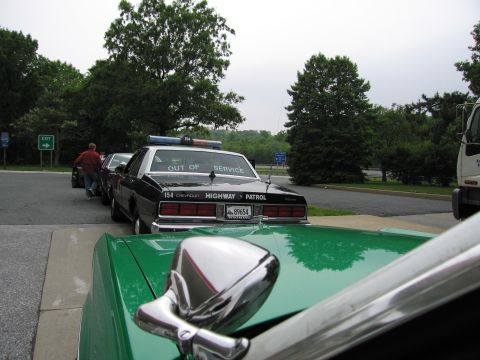 1991 Ford Crown Victoria - A Chevrolet Caprice police car, marked "OUT OF SERVICE", is parked in a line with other vehicles.