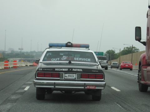 1991 Ford Crown Victoria - Police car with "OUT OF SERVICE" sign on rear window is seen on the highway.