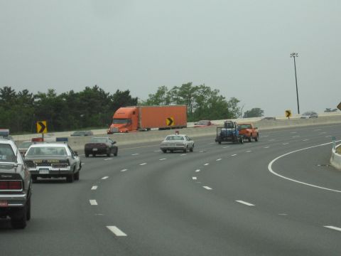 1991 Ford Crown Victoria - A 1991 Ford Crown Victoria police car is seen driving on a highway alongside other vehicles.