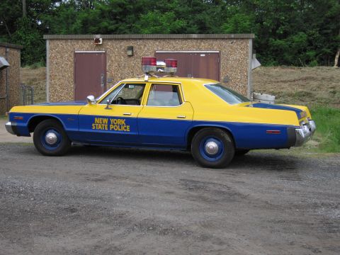 1991 Ford Crown Victoria - This two-tone blue and yellow New York State Police car is parked on a gravel lot.