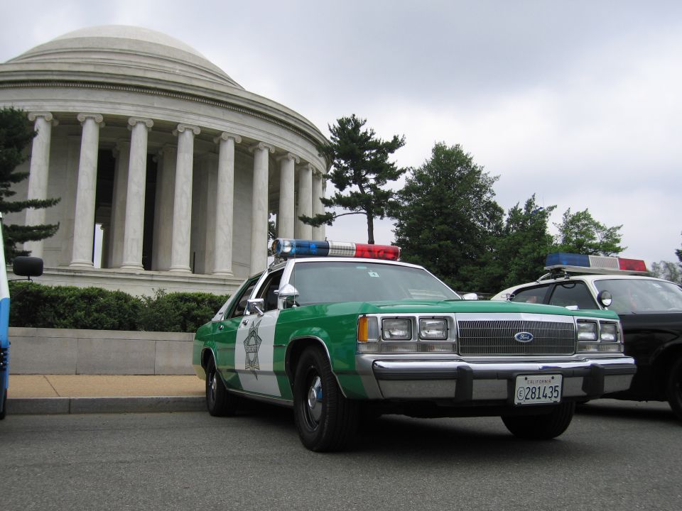 Green and white Ford Sheriff sedan, front three-quarter view, before the domed Jefferson Memorial