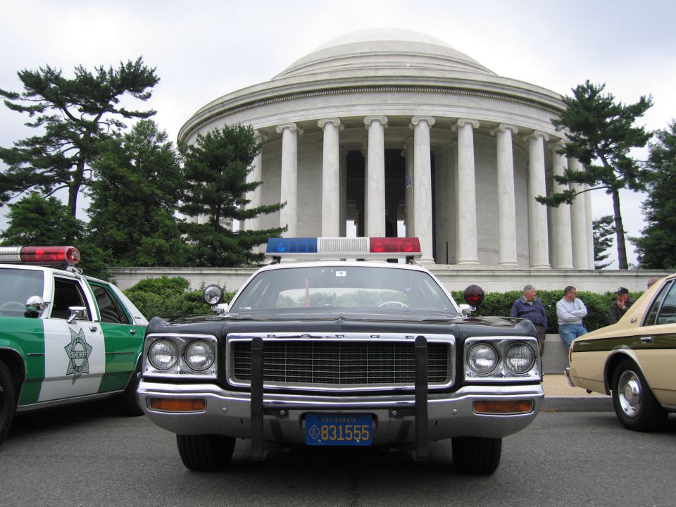 Front view of a black Dodge police sedan with push bar before the domed Jefferson Memorial