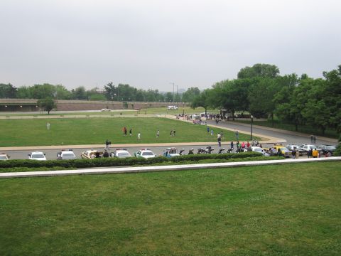 1991 Ford Crown Victoria - A collection of vehicles, including police cars and taxis, are parked in a row on a cloudy day.