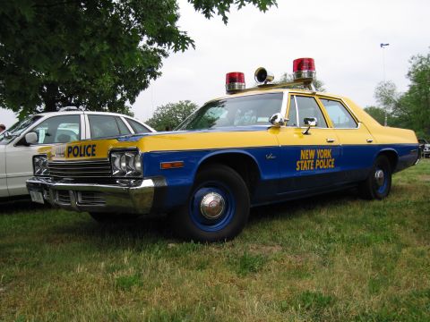 1991 Ford Crown Victoria - A vintage New York State Police car is parked on a grassy field next to another vehicle.