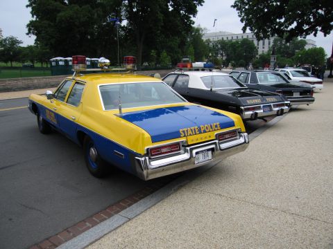 1991 Ford Crown Victoria - Rear view of a 1974 state police car, parked in a line with other vehicles.