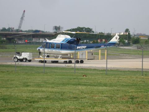 1991 Ford Crown Victoria - A US Park Police helicopter is transported on a trailer, with a utility vehicle in the background.