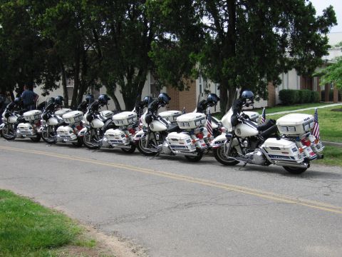 1991 Ford Crown Victoria - Several police motorcycles are lined up on the side of the road, ready for duty.