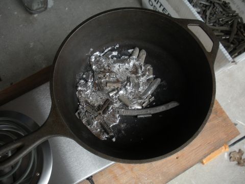 1996 Ford Bronco - Wheel weights are being melted down in a cast iron pan, likely for recycling or repurposing.