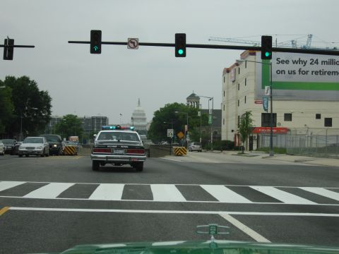 1991 Ford Crown Victoria - A police car with "HIGHWAY PATROL" text on its rear is visible in traffic, with the Capitol building in the background.