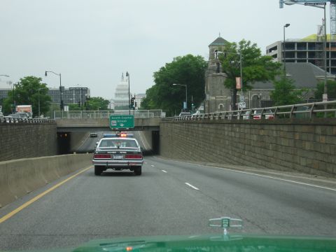 1991 Ford Crown Victoria - A 1991 Ford Crown Victoria police car drives on the highway with the Capitol building in the background.