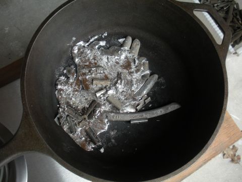 1996 Ford Bronco - Wheel weights are being melted down in a cast iron pot, with some clips visible.