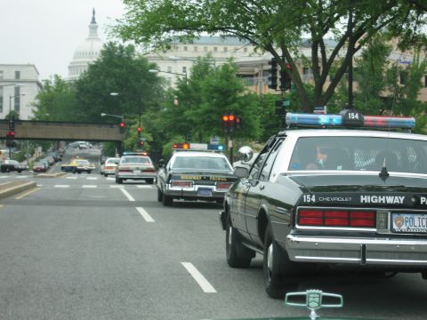 1991 Ford Crown Victoria - Several police vehicles are seen driving in traffic, with the US Capitol building visible in the distance.