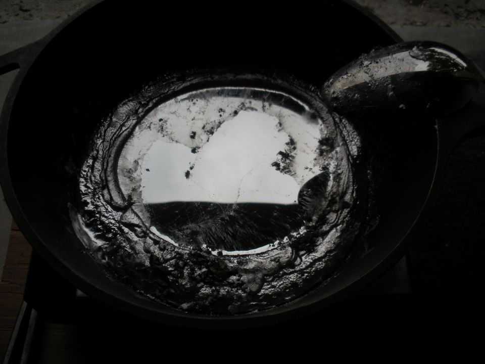 Molten metal in a crucible, with reflections