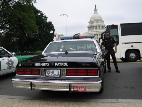 1991 Ford Crown Victoria - A police car with "HIGHWAY PATROL" text on the rear is parked near the Capitol building.