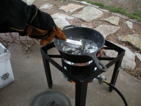 1996 Ford Bronco - Casting metal in a skillet over a propane burner with a gloved hand.