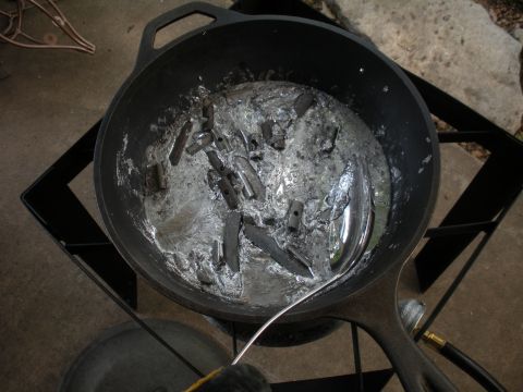 1996 Ford Bronco - Molten metal is being processed in a cast iron pot over a burner, with remnants of previous casting visible.