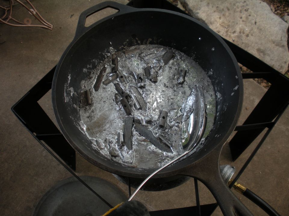 Molten metal in a cast iron pot on a burner