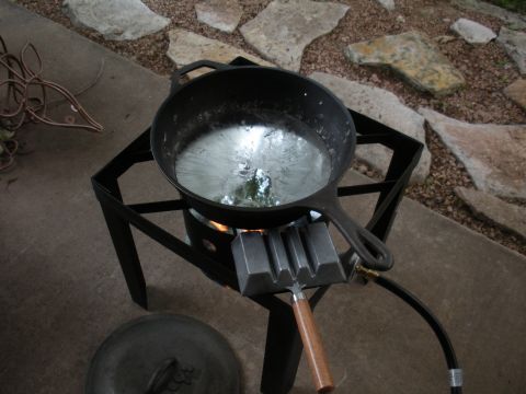 1996 Ford Bronco - Metal is being melted in a cast iron skillet over a propane burner with a mold ready to pour.