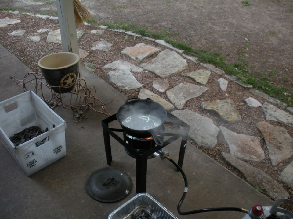 Outdoor cooking setup with boiling pot and crate of seafood