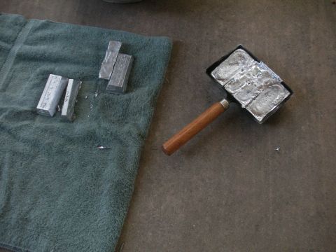 1996 Ford Bronco - A metal casting mold filled with ingots sits next to loose ingots on a towel.