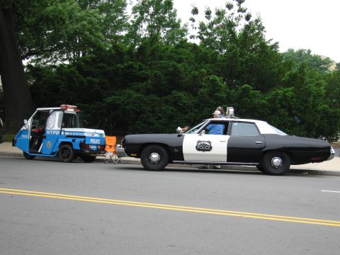 1991 Ford Crown Victoria - Two NYPD vehicles, a full-size sedan and a smaller utility vehicle, are parked side-by-side on a street.