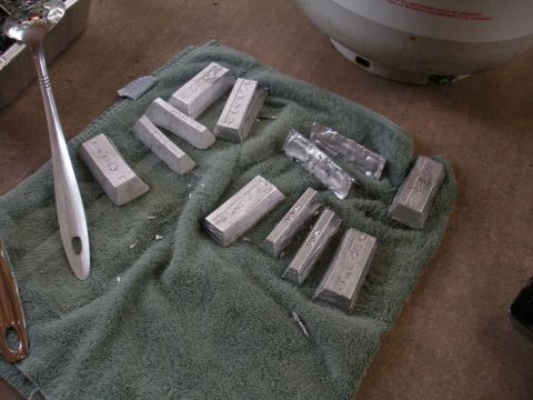 1996 Ford Bronco - Metal ingots are laid out on a towel next to a ladle, ready for use.