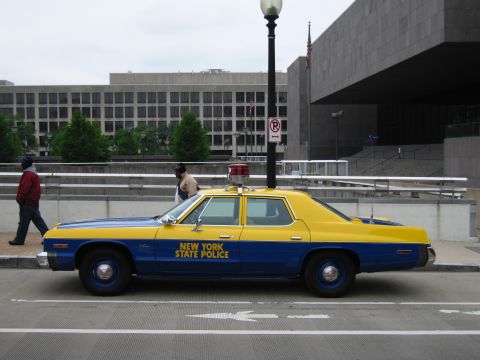 1991 Ford Crown Victoria - Side view of a vintage New York State Police car with blue and yellow livery.