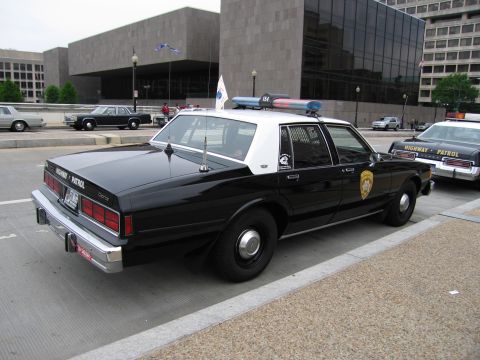 1991 Ford Crown Victoria - A black and white police car with "HIGHWAY PATROL" text is parked next to another police vehicle.