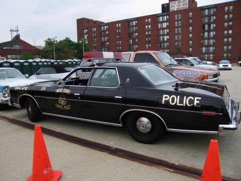 1991 Ford Crown Victoria - A black police car with "UNITED STATES CAPITOL POLICE" text and a light bar is parked next to other vehicles.