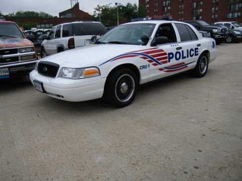 1991 Ford Crown Victoria - Police car parked on concrete with other vehicles nearby.