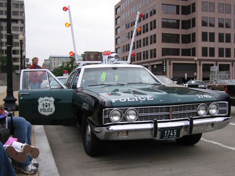 1991 Ford Crown Victoria - This 1969 Ford Custom police car features a distinctive light bar and "POLICE" lettering on the hood.